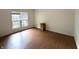 Bedroom with hardwood floors, white walls, and a window overlooking backyard at 4212 Foxglove Trce, Indianapolis, IN 46237