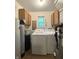 Functional laundry room featuring a washer, dryer, and upper cabinets for storage at 4212 Foxglove Trce, Indianapolis, IN 46237