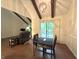 Open-concept living and dining area with vaulted ceiling, wood beams, and sliding doors to deck at 4212 Foxglove Trce, Indianapolis, IN 46237
