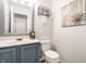 Charming powder room features a blue vanity and decorative mirror, plus a storage shelf at 4227 Short Ter, Carmel, IN 46033