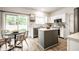 Bright kitchen featuring white cabinets, stainless steel appliances, an island, and an adjacent dining area at 4227 Short Ter, Carmel, IN 46033