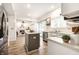 Modern kitchen with white cabinets, stainless steel appliances, and an island, opening to a living area at 4227 Short Ter, Carmel, IN 46033