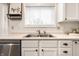 Close-up of the kitchen sink area featuring a stainless steel sink, white cabinets, and light countertops at 4227 Short Ter, Carmel, IN 46033