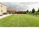 Expansive backyard with patio area featuring a hot tub, fire pit, and lush lawn at 4396 Nigella Dr, Plainfield, IN 46168