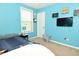 Bright bedroom features blue walls, a white door, shoe storage, and natural light from the window at 4396 Nigella Dr, Plainfield, IN 46168