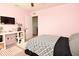 Bedroom features pink walls, neutral carpet, a ceiling fan, and a workspace area at 4396 Nigella Dr, Plainfield, IN 46168