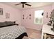 Bedroom features pink walls, neutral carpet, a ceiling fan, and a large window offering plenty of light at 4396 Nigella Dr, Plainfield, IN 46168