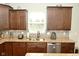 Well-lit kitchen featuring dark cabinets, stainless steel appliances, granite countertops, and stylish tile backsplash at 4396 Nigella Dr, Plainfield, IN 46168
