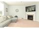 This living room showcases a fireplace, mounted TV, and large sectional couch with pillows for added comfort at 4396 Nigella Dr, Plainfield, IN 46168