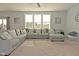 Inviting living room features a sectional couch, ceiling fan, large windows, and a view into the backyard at 4396 Nigella Dr, Plainfield, IN 46168
