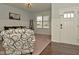 Cozy living room with a white front door, carpeted floors, wainscoting and a large window bringing in natural light at 4396 Nigella Dr, Plainfield, IN 46168