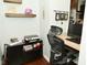 Home office with desk, black rolling chair, shelves, and a view of the kitchen area at 4396 Nigella Dr, Plainfield, IN 46168
