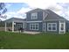 Back exterior featuring a covered patio with outdoor seating, a grill, and a spacious backyard at 4518 W Meadows Ln, New Palestine, IN 46163