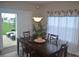 Dining area with a table and six chairs, a modern light fixture, and a sliding glass door to the patio at 4518 W Meadows Ln, New Palestine, IN 46163