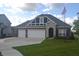 Charming brick home featuring a three-car garage, well-manicured lawn, and an American flag at 4518 W Meadows Ln, New Palestine, IN 46163