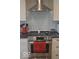 Close-up of a modern kitchen range with a stainless steel hood and white subway tile backsplash at 4518 W Meadows Ln, New Palestine, IN 46163