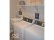 Functional laundry room with modern appliances, including a washer and dryer, plus shelving and decor at 4518 W Meadows Ln, New Palestine, IN 46163