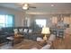 Spacious living room with ample seating, a ceiling fan, and a view into the modern kitchen at 4518 W Meadows Ln, New Palestine, IN 46163
