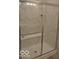 Modern walk-in shower with white marble tile, a glass enclosure, and a built-in bench, showcasing a spa-like retreat at 4518 W Meadows Ln, New Palestine, IN 46163