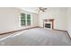 Inviting living room with a cozy fireplace, neutral carpet, and large windows providing natural light at 5 Statesman Ct, Brownsburg, IN 46112