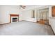 Open-concept living area featuring a fireplace, neutral carpet, and seamless transition to the kitchen and entry at 5 Statesman Ct, Brownsburg, IN 46112