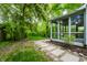 View of back yard showing the sunroom and patio surrounded by grass and trees at 5204 Whipple Wood Ct, Indianapolis, IN 46226