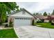 Charming single-story home featuring an attached garage, brick facade, and a well-manicured lawn with mature trees at 5204 Whipple Wood Ct, Indianapolis, IN 46226