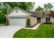 Charming single-story home features brick facade, attached garage, and a well-maintained front yard with mature trees at 5204 Whipple Wood Ct, Indianapolis, IN 46226