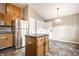 Charming kitchen features stainless steel refrigerator, wood cabinets, island, and modern flooring at 5204 Whipple Wood Ct, Indianapolis, IN 46226