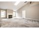 Bright living room with neutral carpeting and vaulted ceilings features a fireplace, skylight, and ample natural light at 5204 Whipple Wood Ct, Indianapolis, IN 46226