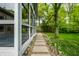 Paver walkway leading along sunroom with many windows to a private backyard at 5204 Whipple Wood Ct, Indianapolis, IN 46226