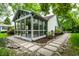 Home exterior showcases sunroom with many windows, stone paver walkway, and landscaping at 5204 Whipple Wood Ct, Indianapolis, IN 46226