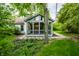 Exterior of sunroom with a peaked roof, lots of windows and green landscaping at 5204 Whipple Wood Ct, Indianapolis, IN 46226