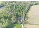 Secluded home nestled in a dense forest, surrounded by green fields and a tranquil pond at 5386 W 1100 N, Fountaintown, IN 46130