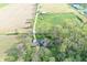 Aerial view showcases a home amidst fields and trees, with a long driveway leading to a main road at 5386 W 1100 N, Fountaintown, IN 46130