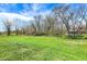 Backyard featuring a large grassy field bordered by bare trees in early spring with a home in the distance at 5386 W 1100 N, Fountaintown, IN 46130