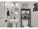 Well-lit powder room with pedestal sink, oval mirror, dark floors, and white doors at 5386 W 1100 N, Fountaintown, IN 46130