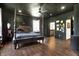 Dark-themed bedroom boasts a four-poster bed, dark floors, dark gray walls, and modern lighting at 5386 W 1100 N, Fountaintown, IN 46130