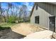 Back exterior view showing a modern farmhouse with a black door and concrete patio at 5386 W 1100 N, Fountaintown, IN 46130