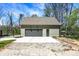 Exterior view of a detached garage with a gray garage door and concrete driveway with space for parking at 5386 W 1100 N, Fountaintown, IN 46130