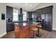 A spacious kitchen with stainless steel appliances and island with wood stools and dark cabinets at 5386 W 1100 N, Fountaintown, IN 46130
