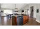View of the island with dark countertops in the kitchen, which opens to the living space and staircase at 5386 W 1100 N, Fountaintown, IN 46130