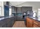 An updated kitchen with a dark countertop, stainless steel refrigerator, and tiled backsplash at 5386 W 1100 N, Fountaintown, IN 46130