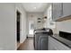 Well-appointed laundry room featuring gray cabinets, black countertops, and modern appliances at 5386 W 1100 N, Fountaintown, IN 46130