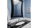 Stylish half-bathroom with blue walls, decorative mirror, and modern fixtures at 548 Lockerbie N Cir, Indianapolis, IN 46202