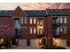 Charming brick townhomes featuring private garages and balconies against a beautiful sunset backdrop at 548 Lockerbie N Cir, Indianapolis, IN 46202