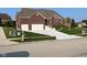 Attractive brick home featuring a manicured lawn, convenient two-car garage, and inviting front entrance at 5601 Harness Dr, Greenwood, IN 46143