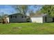 Backyard featuring a grassy area, gray house and a small detached garage with red door at 5831 Aho Dr, Avon, IN 46123
