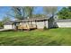 Single-story home with a wooden front porch, garage, and well-kept lawn at 5831 Aho Dr, Avon, IN 46123