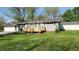 Charming single-story home with gray siding, green lawn, wooden deck and flowerbed at 5831 Aho Dr, Avon, IN 46123
